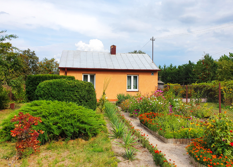 Fotografia domu wiejskiego z ogródkiem autorstwa Ani Wilanowskiej