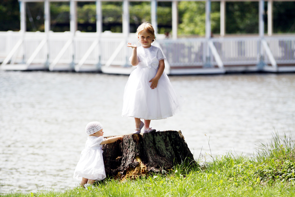 Fotografia dziewczynek w białych sukienkach na konarze drzewa autorstwa Ani Wilanowskiej.
