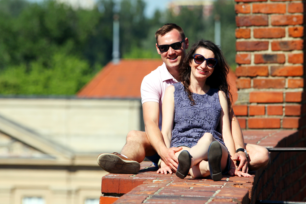 Fotografia pary siedzącej na murku wykonana na Starówce w Warszawie autorstwa Ani Wilanowskiej. 