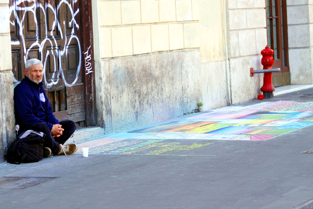Fotografia mężczyzny siedzącego na ulicy wykonana w Rzymie autorstwa Ani Wilanowskiej. 