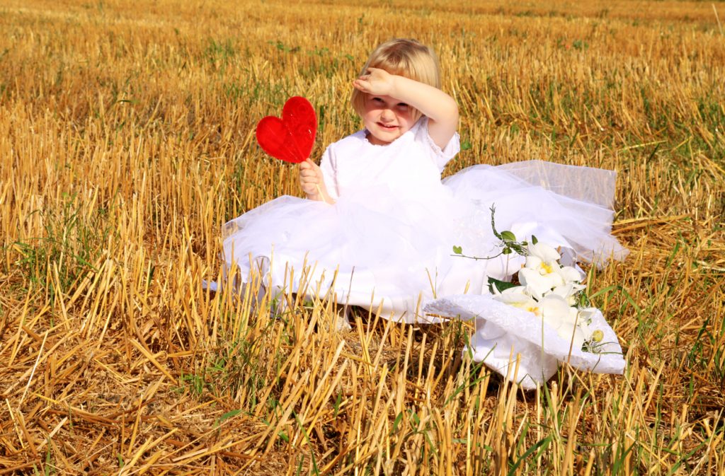 Fotografia dziewczynki w białej sukience na sianie autorstwa Ani Wilanowskiej.