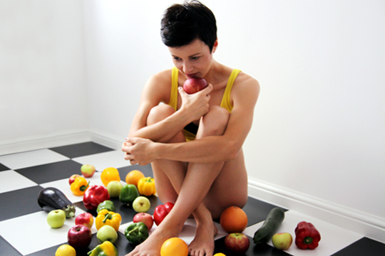 Fotografia kobiety z owocami w kuchni autorstwa Ani Wilanowskiej.