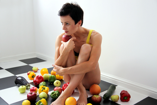 Fotografia kobiety z owocami w kuchni autorstwa Ani Wilanowskiej.
