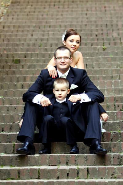 Fotografia młodej pary z synem na schodach wykonana w Łazienkach podczas sesji poślubnej autorstwa Ani Wilanowskiej.
