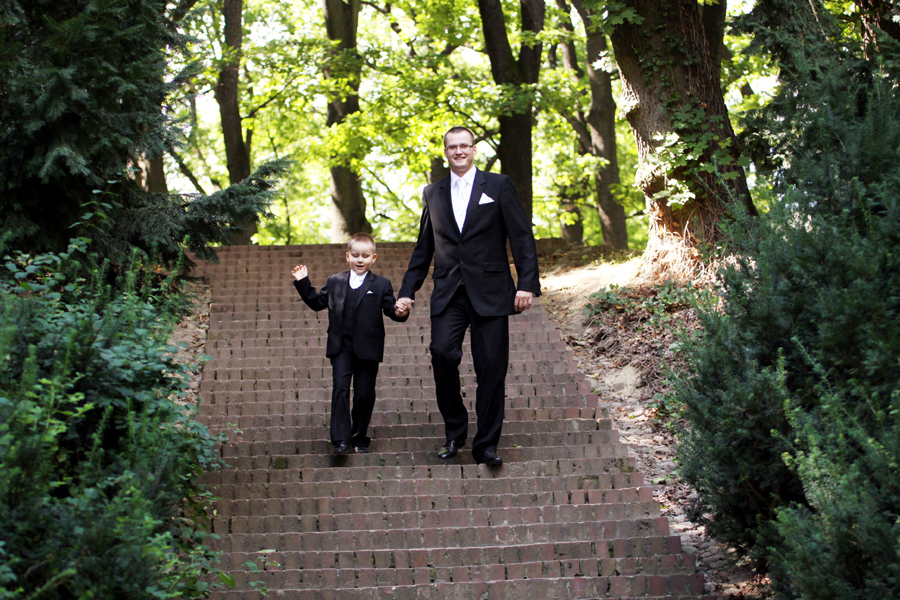 Fotografia ojca i syna zbiegających ze schodów wykonana w Łazienkach podczas sesji poślubnej autorstwa Ani Wilanowskiej.