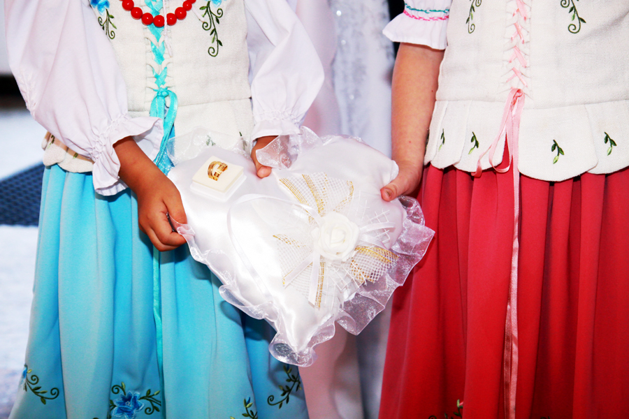 Fotografia dziewczynek trzymających poduszkę wykonana podczas ślubu w kościele autorstwa Ani Wilanowskiej.