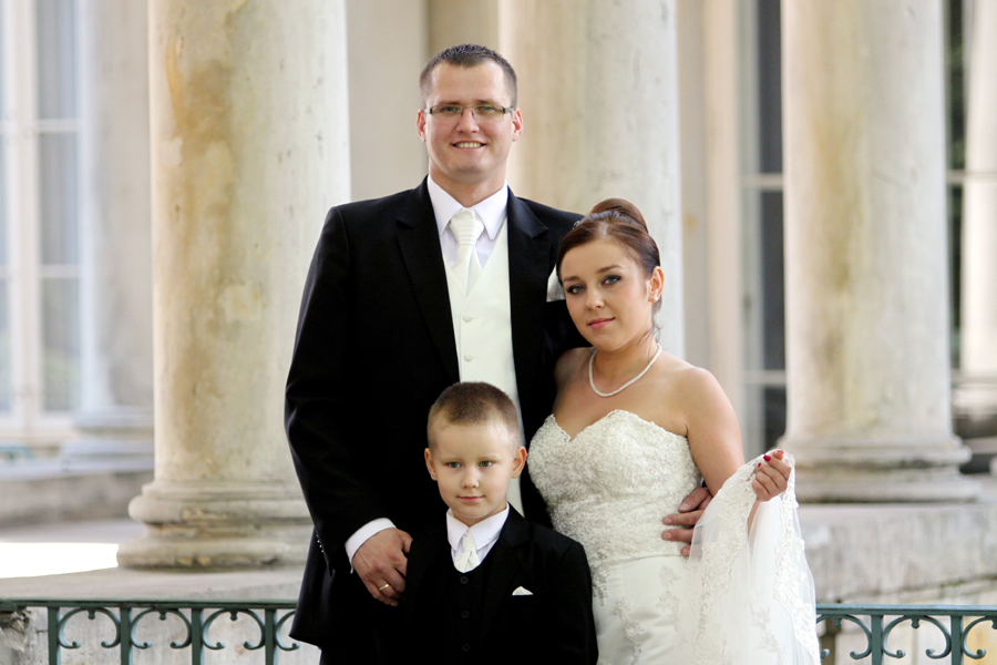 Fotografia młodej pary z dzieckiem wykonana w Łazienkach podczas sesji poslubnej autorstwa Ani Wilanowskiej.