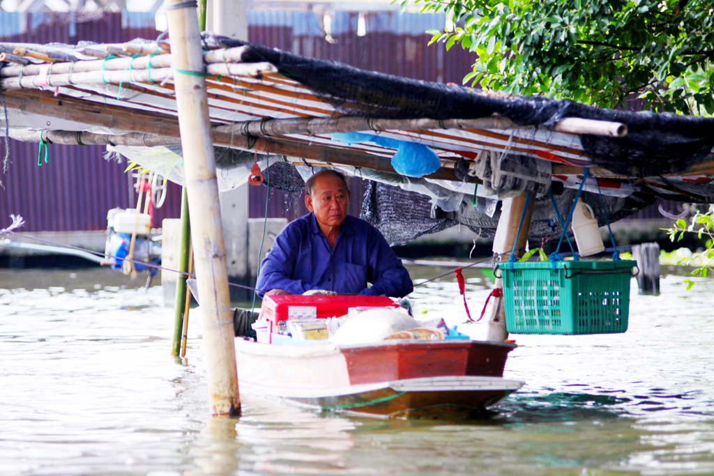 Fotografia mężczyzny na wodzie zrobiona w Bangkoku podczas podróży do Tajlandii. Autorstwa Ani Wilanowskiej.
