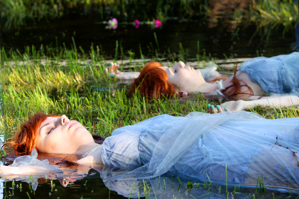Fotografia kobiety leżącej w wodzie na łące autorstwa Ani Wilanowskiej.