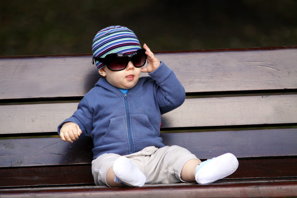 Fotografia dziecka na ławce wykonana w parku na Szczęśliwicach w Warszawie autorstwa Ani Wilanowskiej.