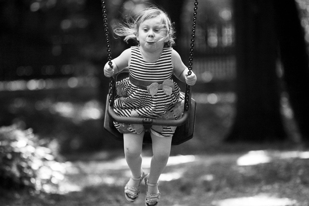 Fotografia dziecka na huśtawce w parku w Łazienkach w Warszawie autorstwa Ani Wilanowskiej