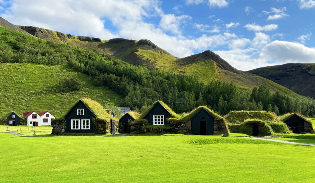 Fotografia domków porośniętych trawą na dachu, zrobiona podczas podróży na Islandię. Autorstwa Ani Wilanowskiej 