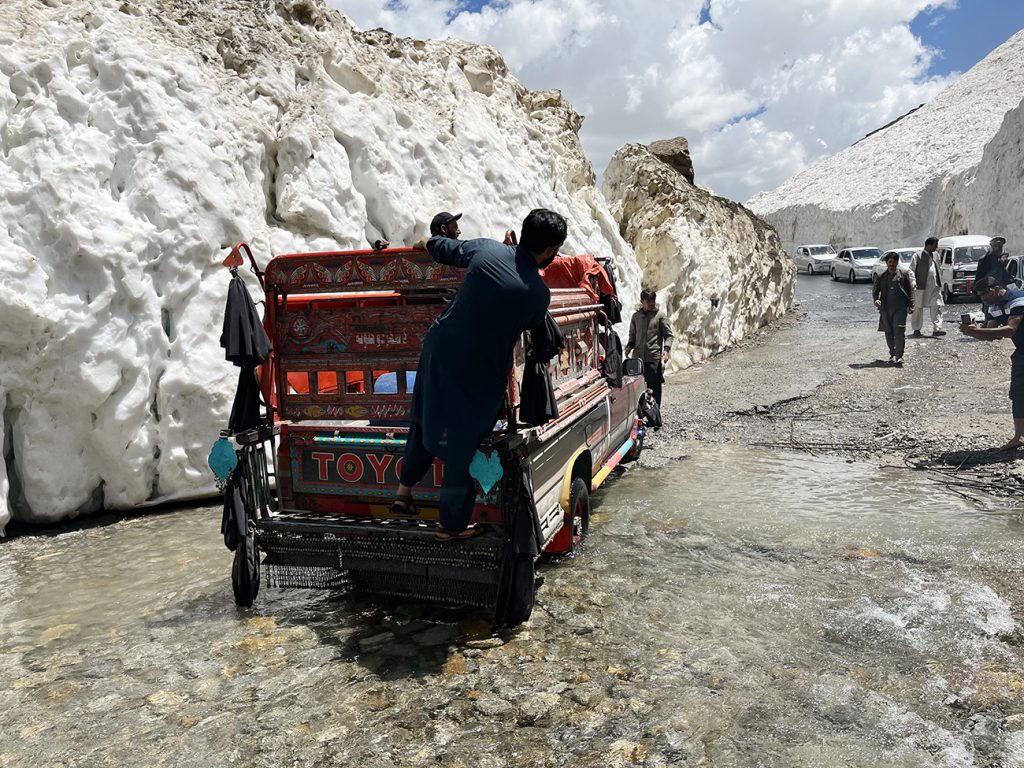 Zdjęcie ludzi przejeżdżających przez zalaną ulicę zrobione w regionie Gilgit-Baltistan w Pakistanie autorstwa Anny Wilanowskiej
