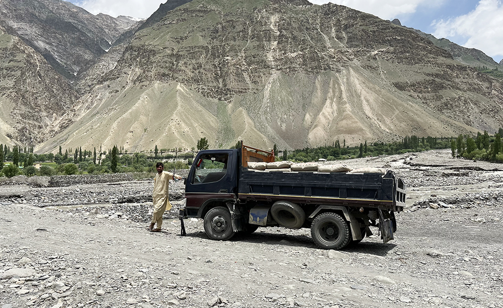 Zdjęcie człowieka i ciężarówki w górach zrobione w regionie Gilgit-Baltistan w Pakistanie autorstwa Anny Wilanowskiej